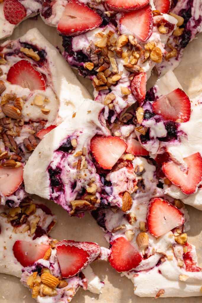 frozen yogurt bark broken into pieces on a tray.