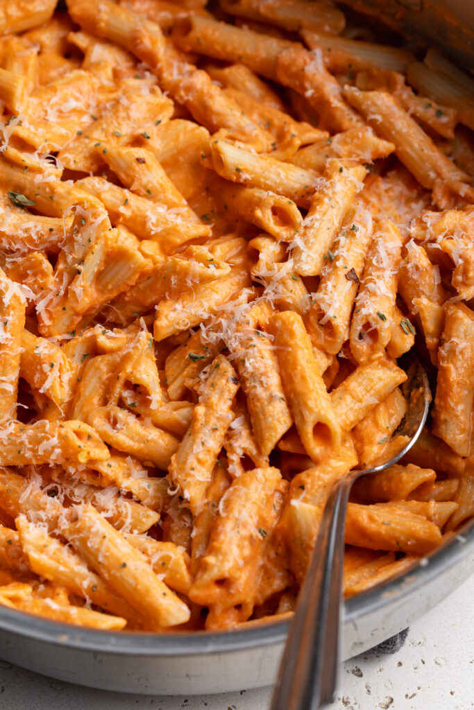 cottage cheese vodka pasta in a skillet with a spoon.