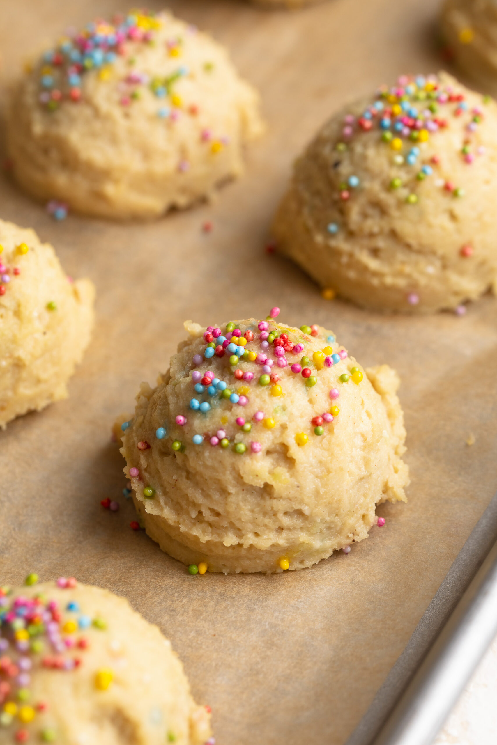 cottage cheese birthday cake bites on a baking sheet with rainbow sprinkles on top.